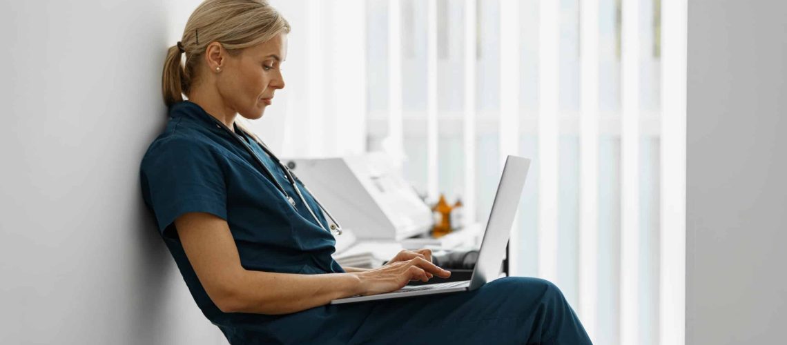 Female healthcare worker using laptop while working at doctor's office